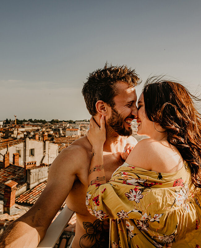 Séance photo d'un couple qui rigole en se faisant un câlin sur les toits de Montpellier