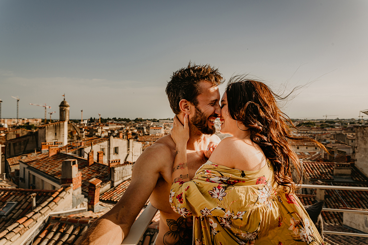 Séance photo d'un couple qui rigole en se faisant un câlin sur les toits de Montpellier