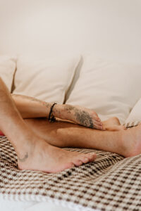 Caresse de pied tatoué d'un couple dans un lit